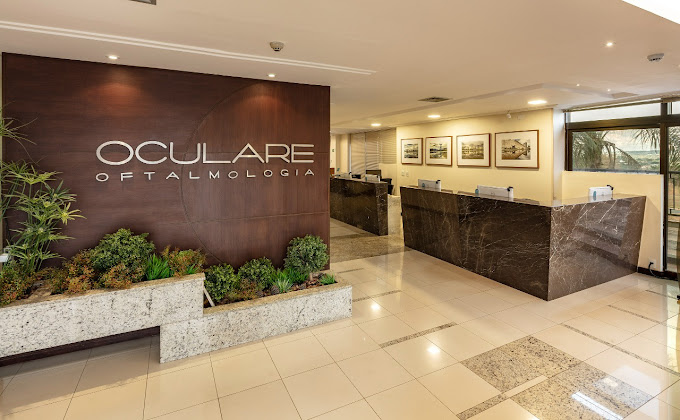 Recepção da clínica Oculare Oftalmologia Asa sul, com a logo na parede e mostrando o balcão de atendimento.